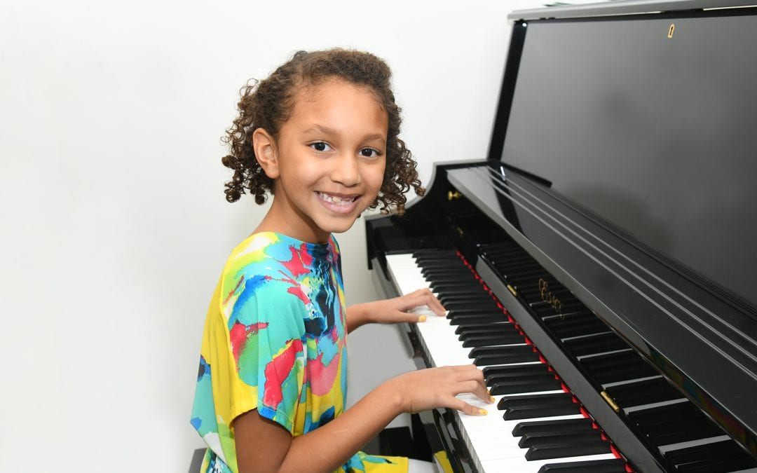 Girl playing piano happily